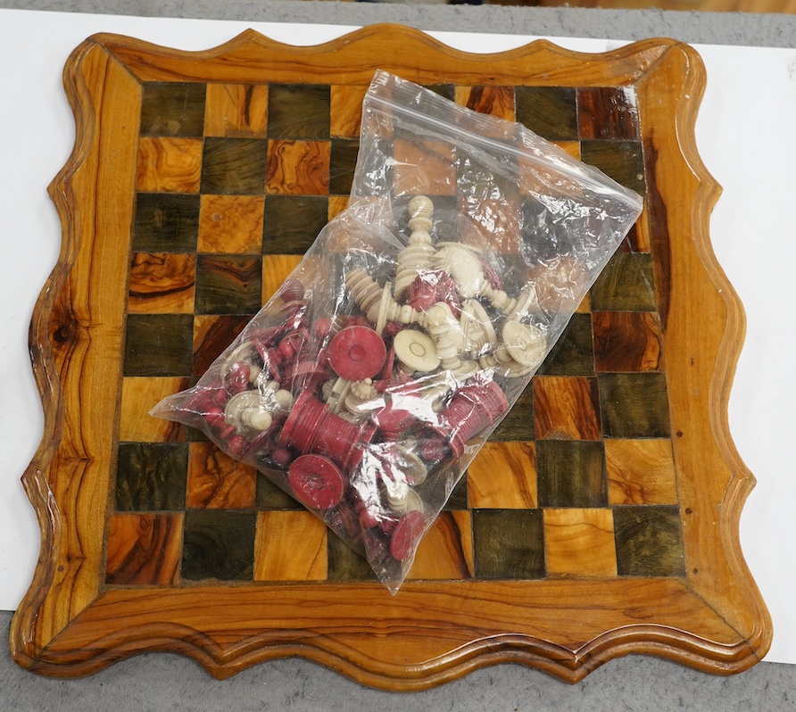 A 19th century stained and natural bone chess set with board, 34cm x 34cm. Condition - fair, some damage to some chess pieces